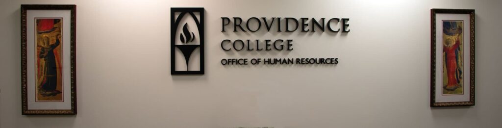 The entry wall in the Human Resources department- it has the text Providence College Human resources along with the torch logo and two paintings flanking it to either side